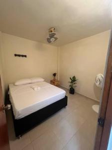Habitación pequeña con cama y baño. en Casa Palomino, cerca a Santorini en Puerto Triunfo