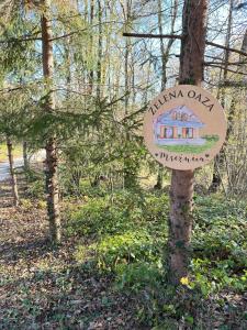 a sign on a tree with a house on it at Mrežnica - Zelena oaza II in Generalski Stol