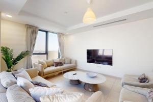 uma sala de estar com um sofá e uma mesa em Janayen Avenue - Locations no Dubai