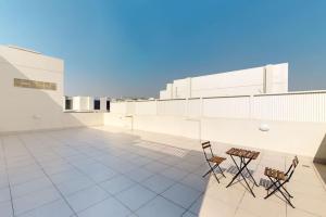 twee stoelen en een tafel op het dak van een gebouw bij Janayen Avenue - Locations in Dubai