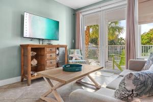 a living room with a tv and a table at Pilot House 412 in Destin