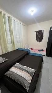 a room with two beds in a room at Hospedagem Recreio dos Bandeirantes in Rio de Janeiro