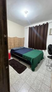 リオデジャネイロにあるHospedagem Recreio dos Bandeirantesのベッドルーム1室(ベッド1台、緑の毛布付)