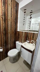 uma casa de banho com um WC, um lavatório e um espelho. em Hospedagem Recreio dos Bandeirantes no Rio de Janeiro