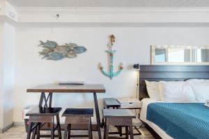 a bedroom with a bed and a table with stools at Harbour Beach Resort 618 in Daytona Beach +27 photos
