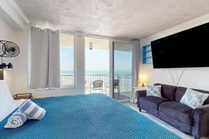 a bedroom with a bed and a couch and a television at Harbour Beach Resort 618 in Daytona Beach