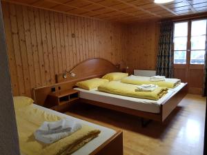 a bedroom with two beds with yellow sheets at Gasthaus Waldhaus in Melchtal