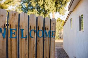 a wooden fence with the welcome sign on it at Sunny Guest Suite with large backyard - Pets Welcome in Phoenix