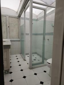 a bathroom with a glass shower and a toilet at Anys Hostal in Mexico City