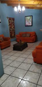 een woonkamer met oranje banken en een tafel bij CABAÑA DOÑA GLORIA in Mazamitla