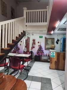 a dining room with a staircase and christmas trees at Anys Hostal in Mexico City