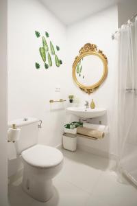 a bathroom with a toilet and a sink and a mirror at Apartamento turístico Travelers in Baena
