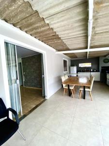 ein Wohnzimmer mit einem Holztisch und einer Küche in der Unterkunft Casa Balneário Picarras in Piçarras