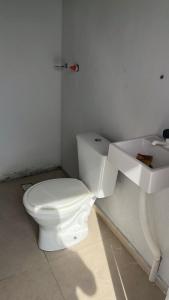 ein Badezimmer mit einem weißen WC und einem Waschbecken in der Unterkunft Casa Balneário Picarras in Piçarras