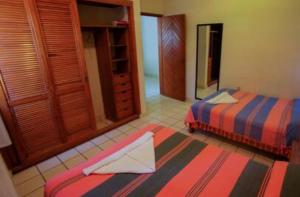 1 dormitorio con 2 camas y espejo. en Bungalows Oasis, en Puerto Escondido