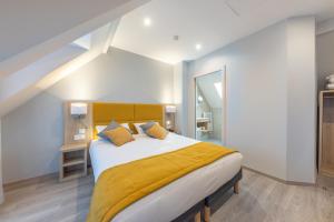 ストラスブールにあるHotel Saint Augustinのベッドルーム1室(大型ベッド1台、黄色い毛布付)
