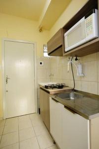 a small kitchen with a sink and a microwave at Apto Centro Histórico ótima localização e iluminado in Porto Alegre