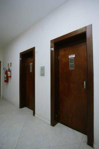 due porte in legno in un corridoio di un edificio di Apto Centro Histórico ótima localização e iluminado a Porto Alegre