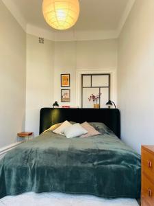a bedroom with a large bed with a green blanket at Cool and light 2 room apartment in SoFo in Stockholm