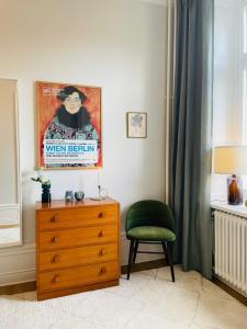 a bedroom with a dresser and a green chair at Cool and light 2 room apartment in SoFo in Stockholm