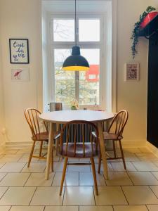 a dining room table with chairs and a pendant light at Cool and light 2 room apartment in SoFo in Stockholm
