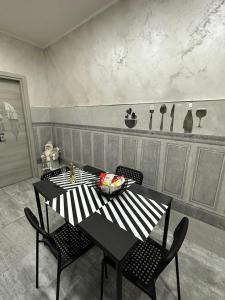 een eetkamer met een zwarte tafel en stoelen bij C.D.M in Napels +5 foto's