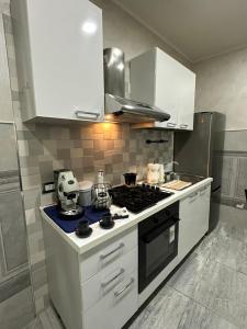 een keuken met een fornuis en witte kasten bij C.D.M in Napels