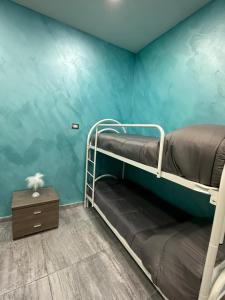 een kamer met 2 stapelbedden en een blauwe muur bij C.D.M in Napels