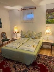 ein Bett in einem Schlafzimmer mit zwei Lampen und zwei Stühlen in der Unterkunft Haus Lüftleck in Lunz am See
