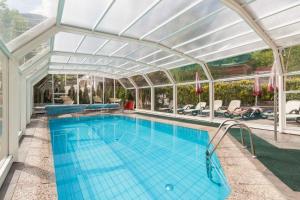 an indoor swimming pool with a glass ceiling at Pension Sonnegg in Saltusio