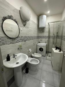 een badkamer met een wastafel, een toilet en een spiegel bij C.D.M in Napels