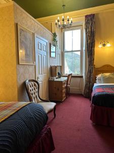 a hotel room with two beds and a desk and a window at Rosehall Hotel in Edinburgh +197 photos