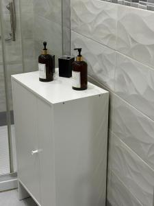 twee flessen zeep bovenop een witte kast bij C.D.M in Napels