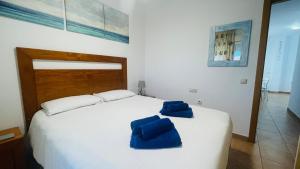 a bedroom with a large white bed with blue chairs on it at Casa Tranquila Oliastur 17 El Cotillo in Cotillo +20 photos