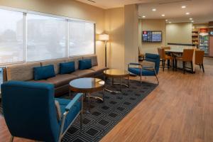uma sala de espera com um sofá, cadeiras e uma mesa em TownePlace by Marriott Suites Clarksville em Clarksville