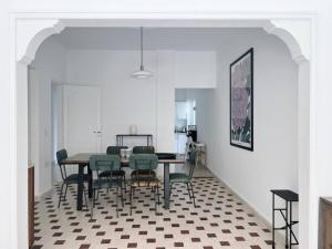 a dining room with a table and green chairs at Sunny Eclectic 3BR house in Gemmayze in Beirut