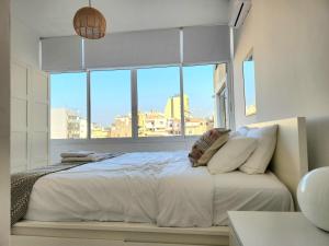 a bedroom with a bed with a large window at Sunny Eclectic 3BR house in Gemmayze in Beirut