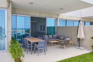 a patio with a table and chairs and an umbrella at Amchit Bay Beach Residences 2BR w Private Pool in Jbeil