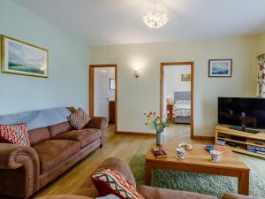 a living room with a couch and a tv at 2 Bed in Sidmouth LAMBS in Ottery Saint Mary