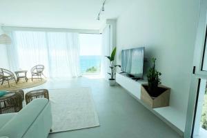 - un salon avec un canapé, une télévision et une table dans l'établissement Amchit Bay Beach Residences 3BR w Indoor Jacuzzi, à Byblos