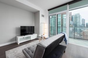 ein Wohnzimmer mit einem Sofa und einem großen Fenster in der Unterkunft Toronto Condo with a View, St. Lawrence Market in Toronto