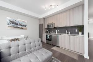 a living room with a couch and a kitchen at Toronto Condo with a View, St. Lawrence Market in Toronto