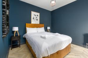 a bedroom with a large bed with blue walls at Ettie and Gigi's in Blackpool