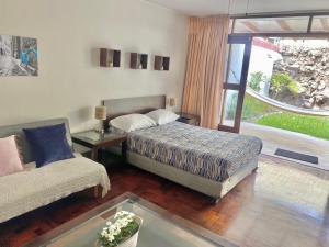 a bedroom with a bed and a couch and a window at Lima Mini Aparts Monterrico - Cerca Embajada EEUU in Lima