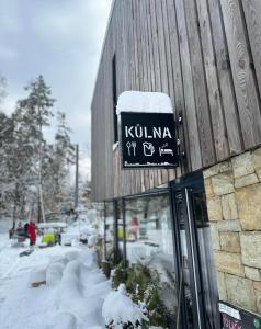 Penzion Kůlna في Slatiňany: علامة على جانب مبنى في الثلج