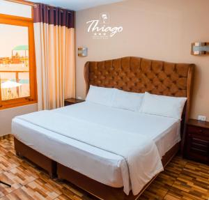 a bedroom with a large bed with a large window at Hotel Resort Thiago in Chincha Alta