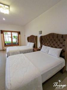 Habitación de hotel con 2 camas y ventana en Hotel Resort Thiago, en Chincha Alta