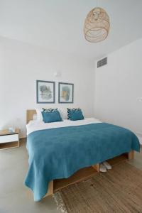 a bedroom with a large bed with a blue blanket at Amchit Bay Beach Residences 3BR Rooftop w Jacuzzi in Jbeil