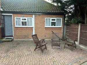 two chairs and a grill in front of a house at Airport Retreat in Handforth