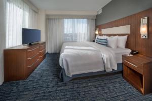 a hotel room with a bed and a flat screen tv at Residence Inn by Marriott Baltimore at The Johns Hopkins Medical Campus in Baltimore